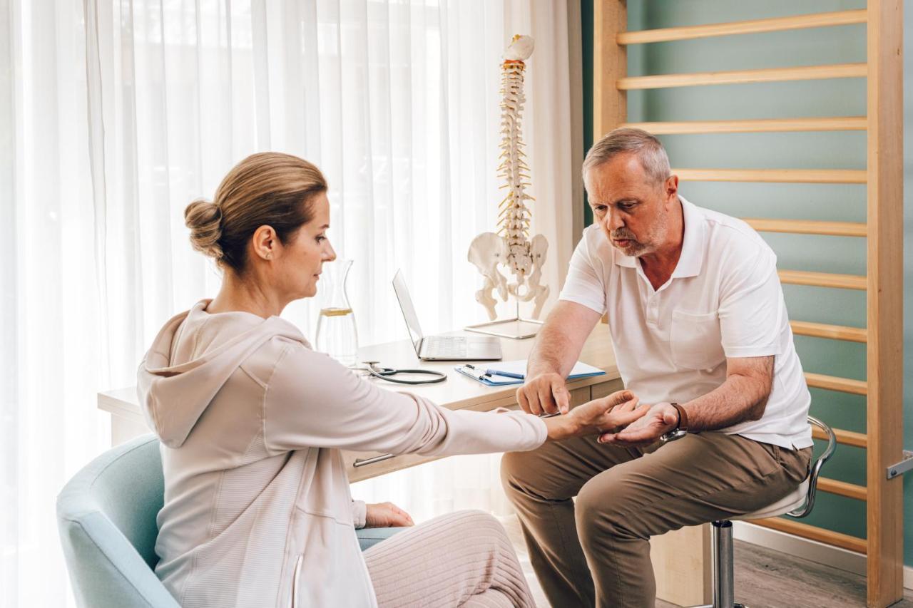 Falkensteiner Spa Resort Mariánské Lázně Esterno foto A chiropractor examines a patient's wrist